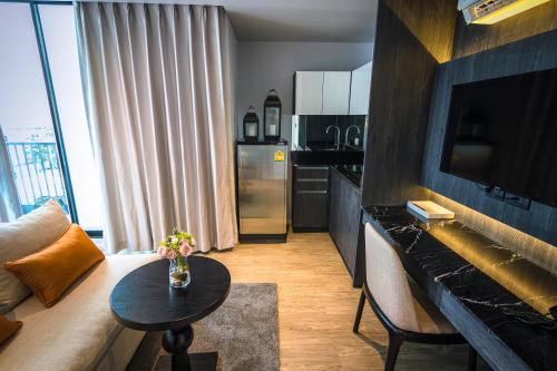 a living room with a couch and a table at Apartelle Jatujak Hotel in Bangkok