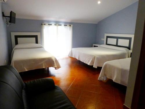 
a hotel room with two beds and a television at Hostal San Miguel in Trujillo
