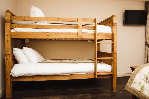 two bunk beds in a room with a television at Glen Clova Hotel & Luxury Lodges in Millton of Clova