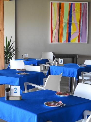 een kamer met blauwe tafels en witte stoelen bij Wilderness Beach Views in Wilderness