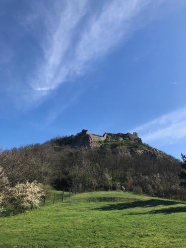 a hill with a castle on top of it at VÁR-CAMPING in Sirok