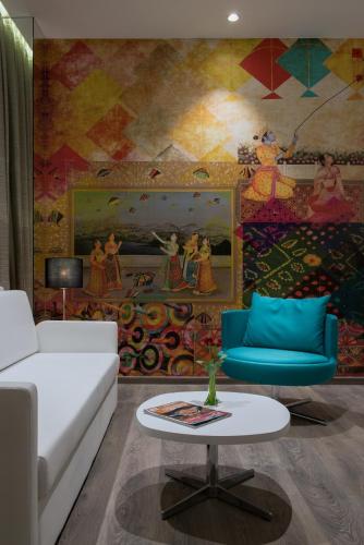 a living room with a couch and a mural at Eastin Residences Vadodara in Vadodara