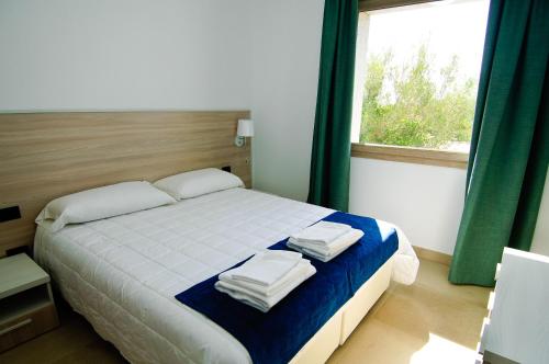 una camera da letto con un letto e asciugamani di Villa Marianna a Castiadas