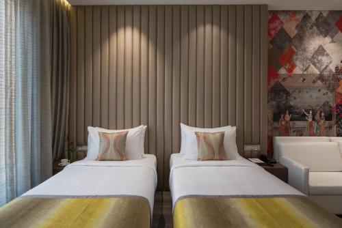 a hotel room with two beds in a room at Eastin Residences Vadodara in Vadodara