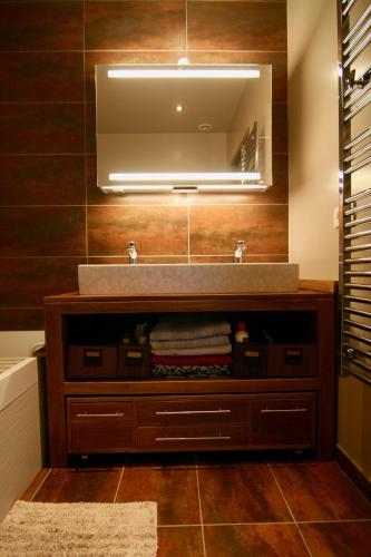 une salle de bain avec un lavabo et un miroir dans l'établissement bibou's room Paris, aux Lilas
