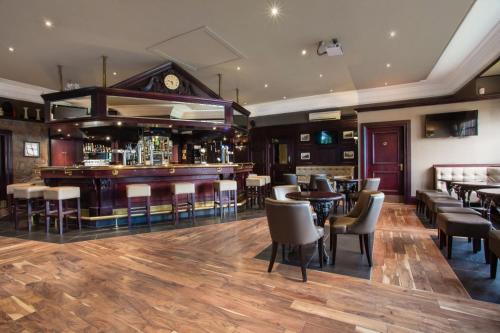 a bar in a restaurant with tables and chairs at The Parkville Hotel in Hamilton