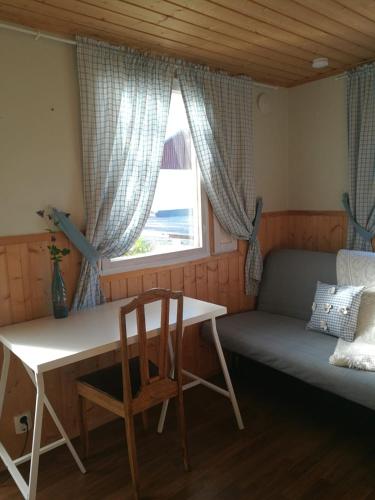 een kamer met een bed, een tafel en een raam bij Willa Mustijoki in Laukkoski