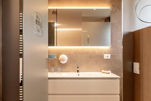 W łazience znajduje się umywalka i lustro. w obiekcie Landgasthof Bad Turmbach w mieście Appiano sulla Strada del Vino