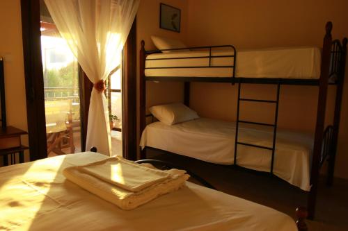two bunk beds in a room with a window at Katina's House in Vourvourou