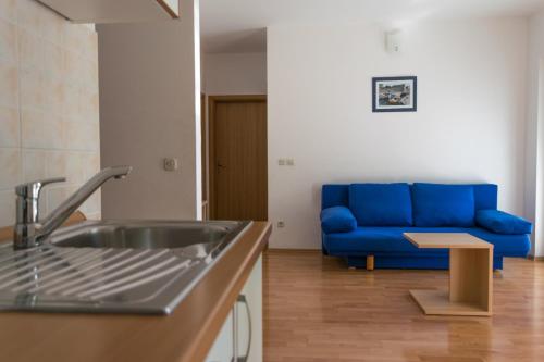 a kitchen with a sink and a blue couch at House Vera in Baška Voda