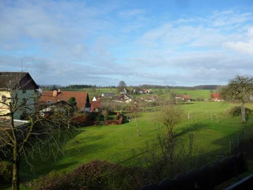 uma vista para um campo verde com casas e árvores em Ferienwohnung Am Limespfad em Hesselbach