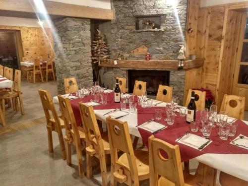 a dining room with a table and a fireplace at Delfin Dal Pianhol in Casteldelfino