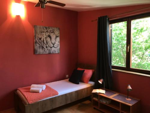 - une chambre avec un lit aux murs rouges et une fenêtre dans l'établissement Apartment Mia, à Seline