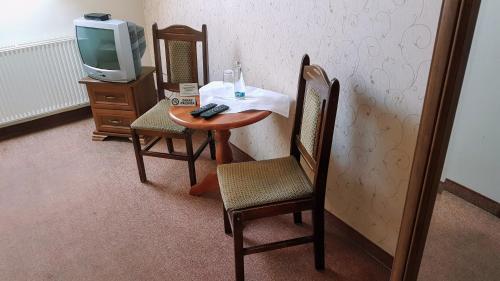 Cette chambre dispose d'une table, de deux chaises et d'une télévision. dans l'établissement Kania Pokoje Gościnne, à Przodkowo