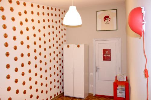 a room with a wall with a white refrigerator at La Sosta Navarra Bed & Beer in Gubbio