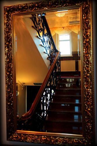 a mirror with a reflection of a staircase in a room at Hotel Zaodrze in Opole