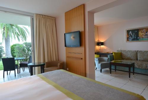 a hotel room with a bed and a living room at Hôtel Restaurant Dolce Vita in Ajaccio