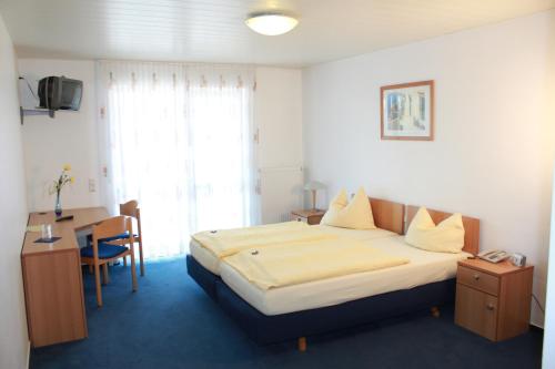 um quarto de hotel com uma cama, uma secretária e uma cadeira em Hotel Gramlich em Heddesheim