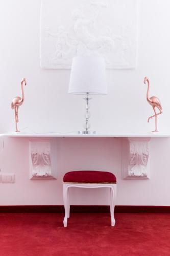 a white room with a red bench and two pink flamingos at Villa Marini Trevisan in Aviano