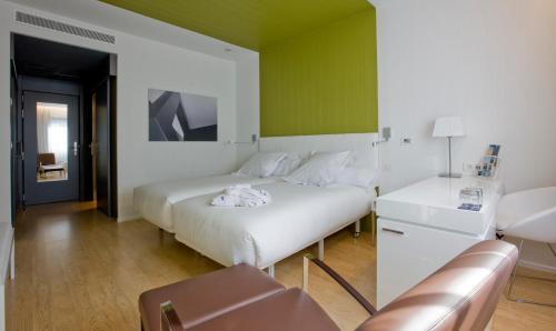 a bedroom with a white bed and a green wall at Hotel Zentral Castellana Norte in Madrid
