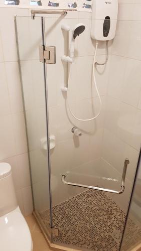 baño con aseo y puerta de ducha de cristal en Divers Lodge Moalboal, en Moalboal