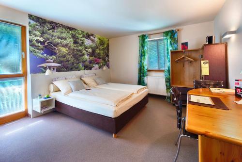 een slaapkamer met een groot bed en een bureau bij Hotel Schindlerhof in Neurenberg