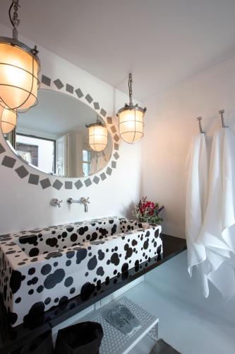 a bathroom with a large mirror and a sink at Erosantorini Luxury Private Estate & Suites in Fira
