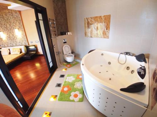 un bagno con una vasca da bagno con una mucca sul pavimento di Сучасна Вілла з басейном на приватній території a Odessa