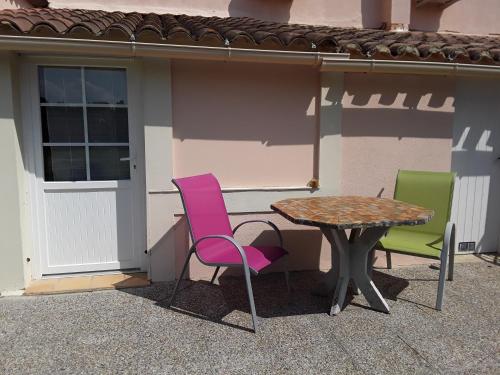 3 chaises et une table devant un bâtiment dans l'établissement L'Oustau de MaLo, à Sainte-Cécile-les-Vignes