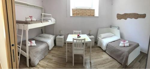 Cette petite chambre comprend 2 lits superposés et une table. dans l'établissement Arco dolce Arco, à Bénévent