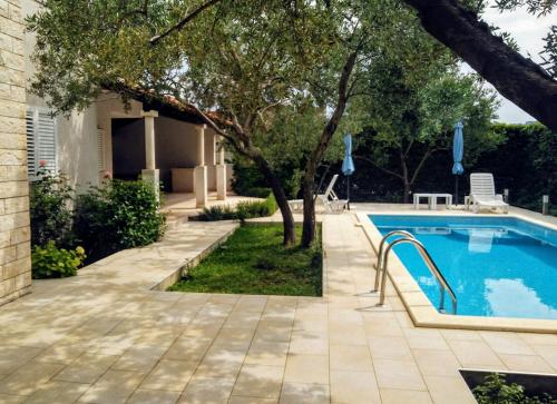 een zwembad in een tuin naast een huis bij Villa Donadini in Trogir