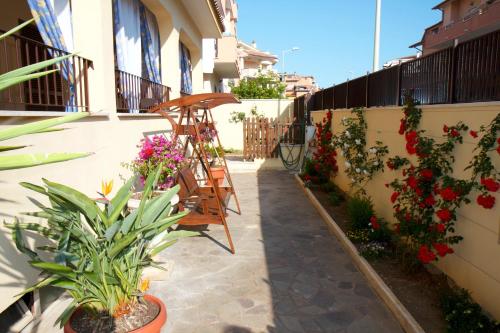 a patio with flowers and a ladder on a building at Domus Palombi in Ladispoli