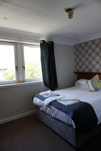 a bedroom with a bed with towels on it at Boreland Lodge Hotel in Inverkeithing