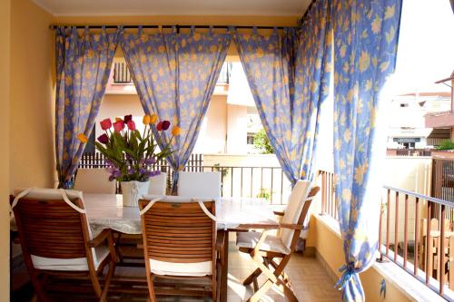 a dining room with a table and chairs and a window at Domus Palombi in Ladispoli