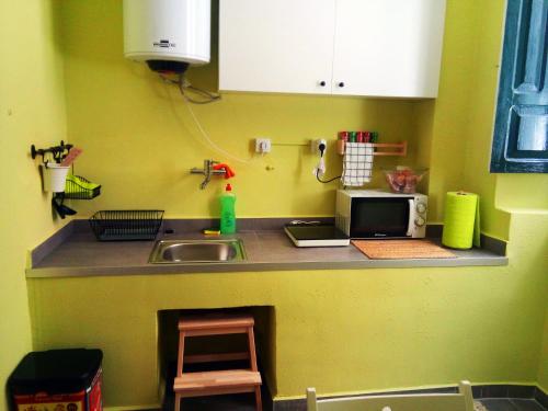 a kitchen counter with a sink and a microwave at Albergue San Lázaro in Sarria