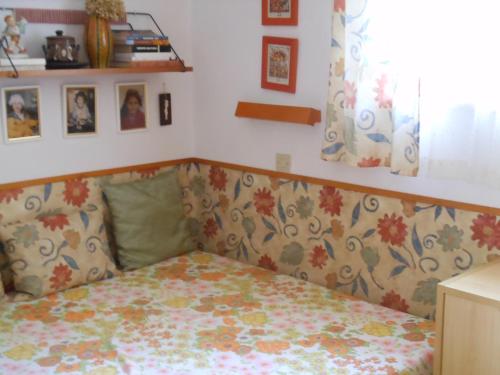 1 Schlafzimmer mit einem Bett mit Blumenbettdecke in der Unterkunft Cozy Family Cottage at the Lake in Siófok