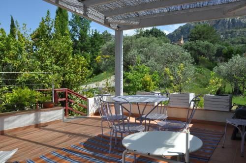 a patio with a table and chairs on a deck at Le Jas Du Colombier in Moustiers-Sainte-Marie