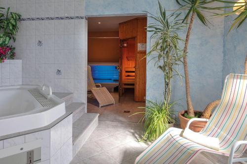 a bathroom with a tub and two chairs and palm trees at Hotel Deutsche Flagge in Binz