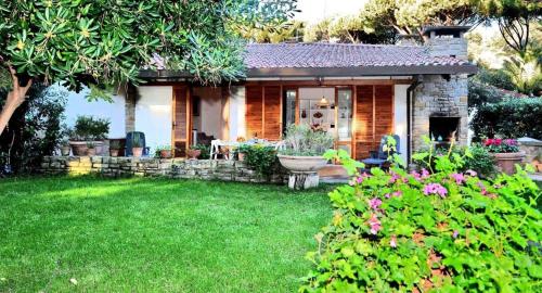 a small house with a garden and a lawn at Villa Ancora in Castiglione della Pescaia
