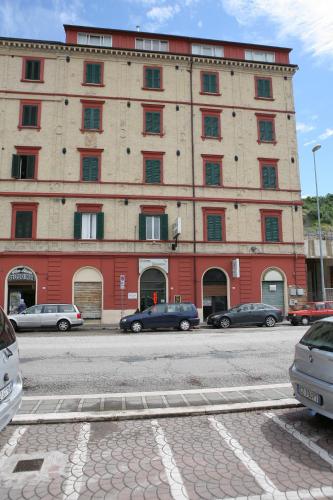 a large red building with cars parked in front of it at Hotel Dorico in Ancona