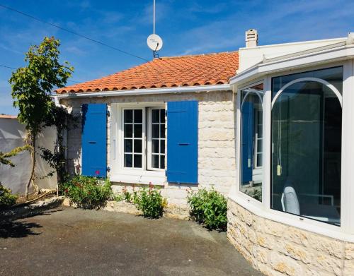 une petite maison avec des portes bleues dans l'établissement Cosy villa La Garancière - Plein coeur de la Cotinière, à La Cotinière
