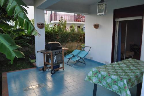 een grill op een patio met een tafel en stoelen bij Arancio residence in Taormina