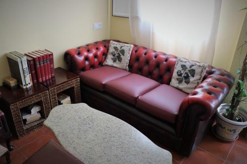 a red leather couch in a living room at Hostal Arco Plaza in Mojácar