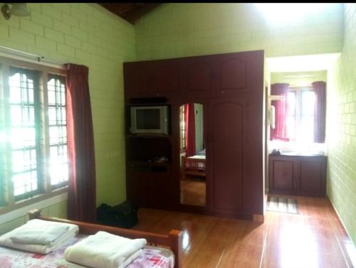 a room with a bed and a tv on a wall at The Four Seasons in Kalpetta