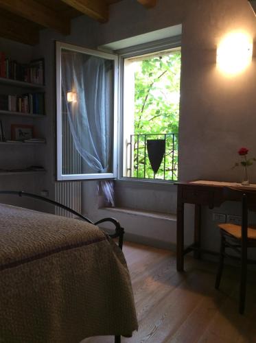 una camera con letto e finestra con scrivania di B&B Locus Amoenus a Vobarno