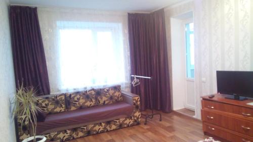 - un salon avec un canapé et une fenêtre dans l'établissement Apartment on Prospekt Peremogi, à Tchernihiv
