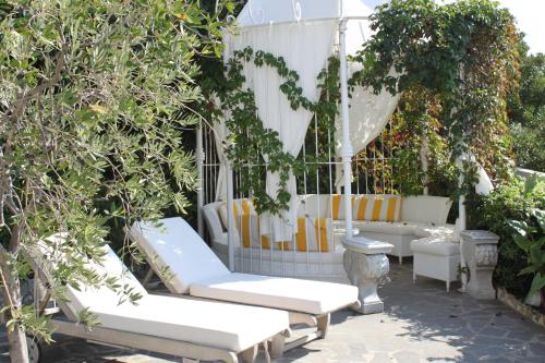 a group of white couches sitting in a garden at Hotel Helvetia in Sestri Levante