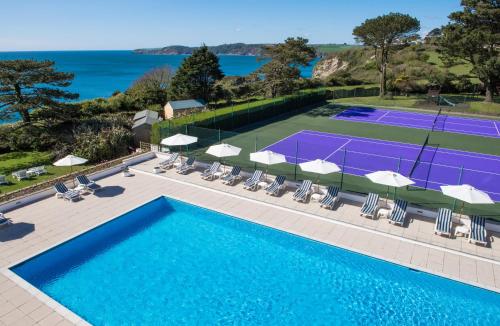 an overhead view of a tennis court with chairs and a pool at The Carlyon Bay Hotel and Spa in St Austell