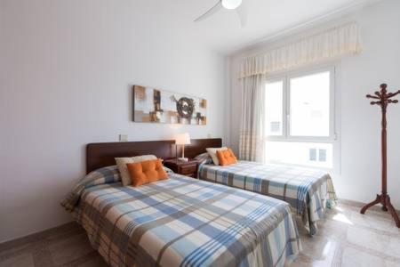 sypialnia z dwoma łóżkami i oknem w obiekcie Apartamentos Castillo Mar Gran Canaria w mieście Castillo del Romeral