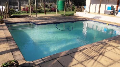 a swimming pool with a hose in the water at Jacaranda Guesthouse in Eshowe